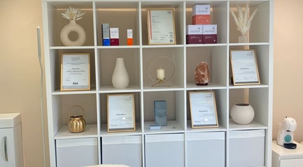 Elegant shelves at Bespoke Skin, Hoddesdon, England showcasing certificates and decor.