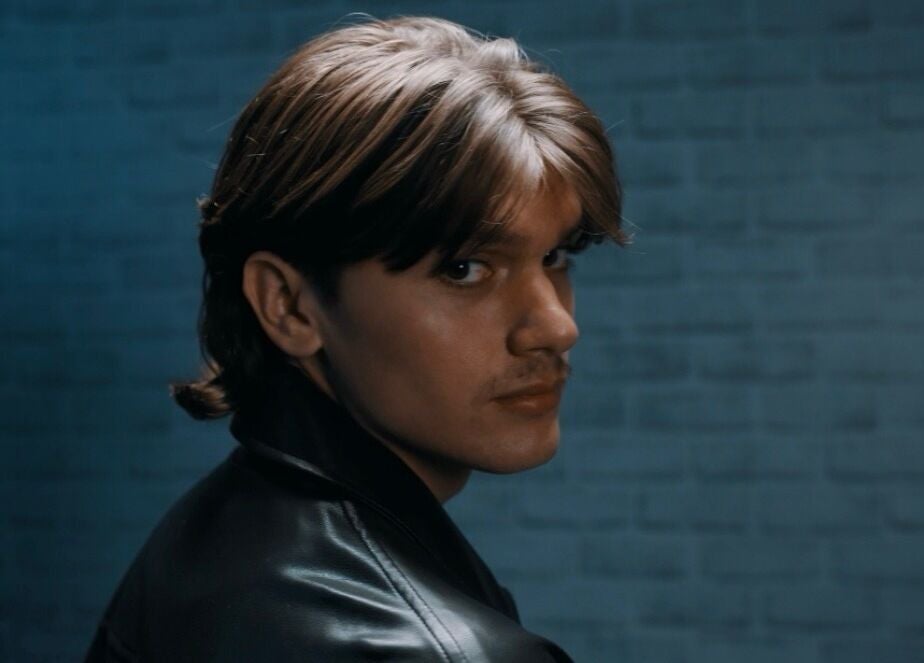 Chic hairstyle model at Terribile Barber Shop in Birkirkara, MT with a sleek leather jacket.