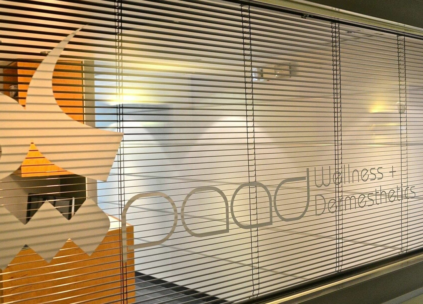 Paad Wellness and Derm Esthetics window in Vancouver, British Columbia, CA with stylish blinds and logo.