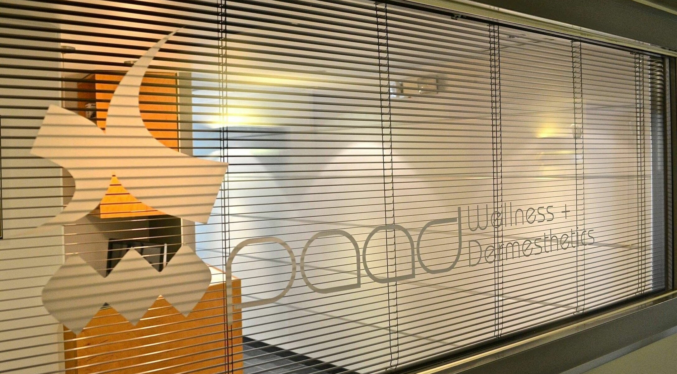 Paad Wellness and Derm Esthetics window in Vancouver, British Columbia, CA with stylish blinds and logo.