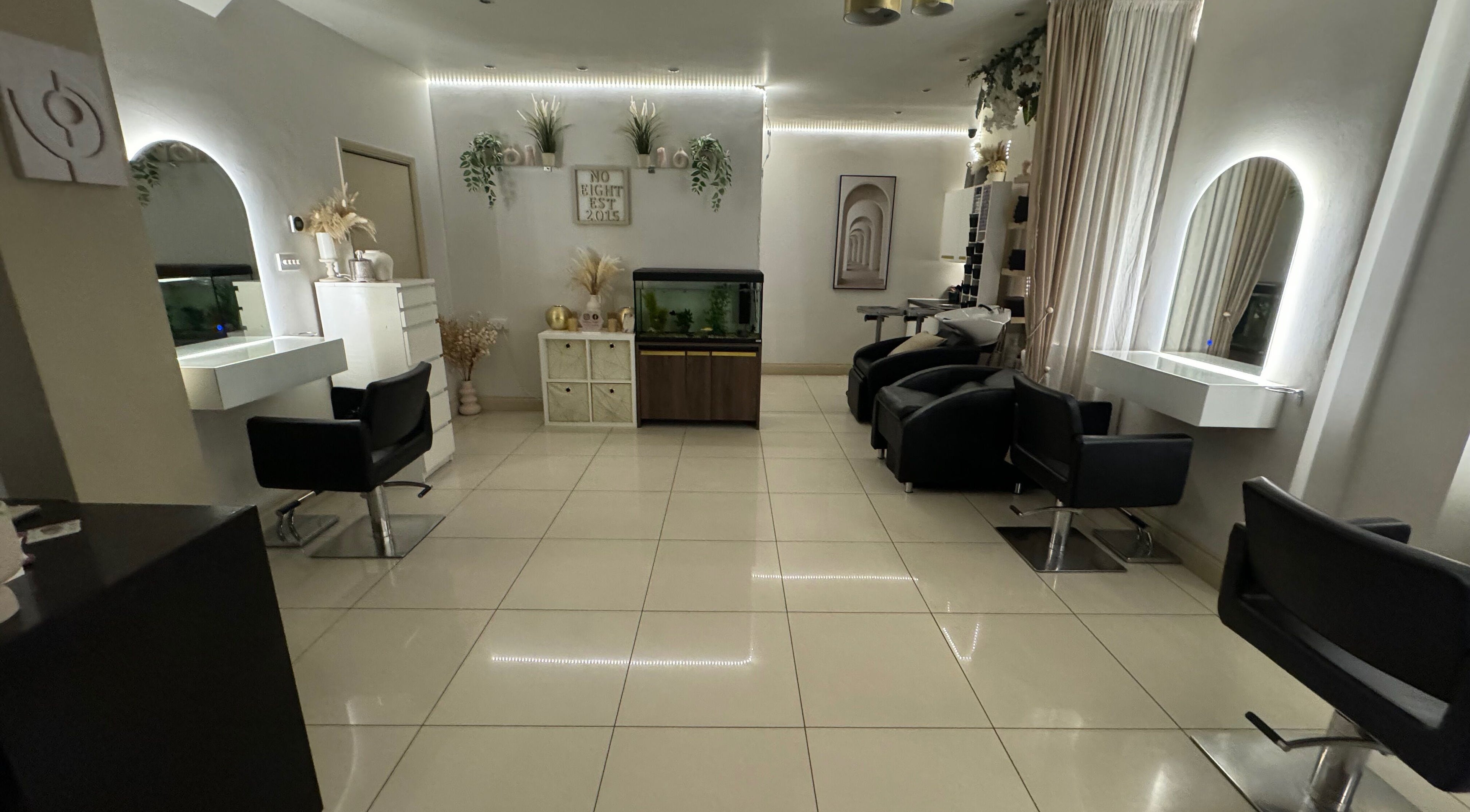 Modern interior of Salon No.Eight in Esher, England, GB with sleek styling stations and elegant lighting.