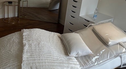 Tranquil treatment room at The Hair Studio in Sudbury, England, GB with cozy bed and elegant decor.