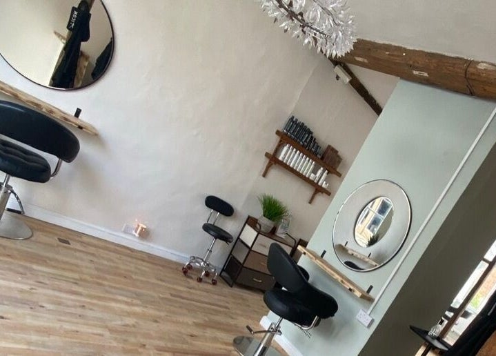 Modern interior of The Hair Studio in Sudbury, England, GB, featuring styling chairs and wall mirrors.