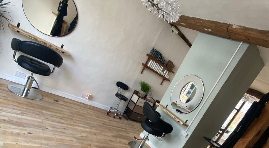 Modern interior of The Hair Studio in Sudbury, England, GB, featuring styling chairs and wall mirrors.