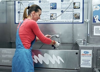 Ragazza utilizza una doccia per lavare un cane a WASH DOG 24h – DALMINE, Dalmine, Lombardia, IT.