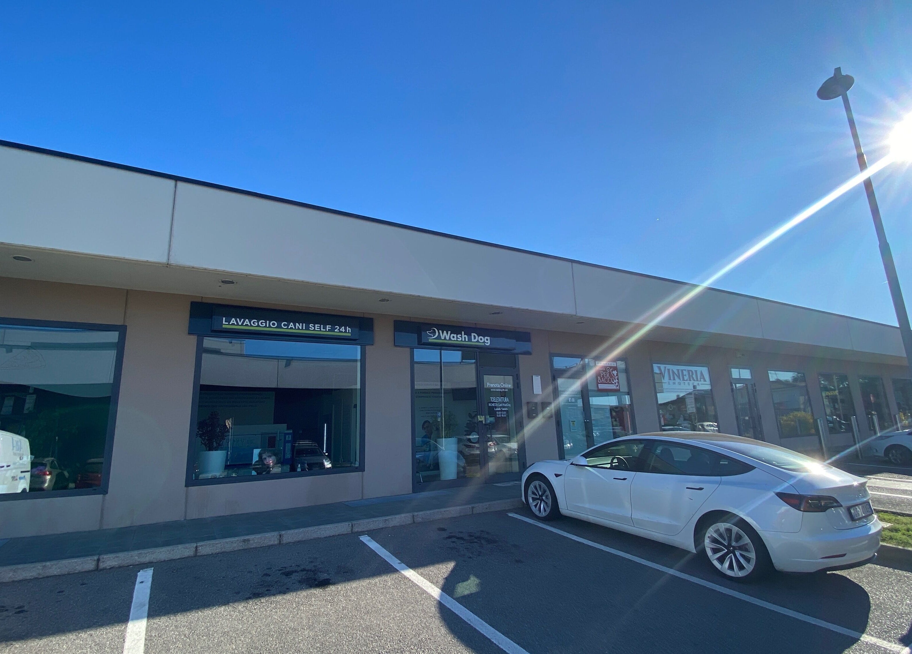 Esterno di AB Toelettatura Luxury Dalmine BG a Dalmine, Lombardia, IT con vetrine e auto parcheggiata.