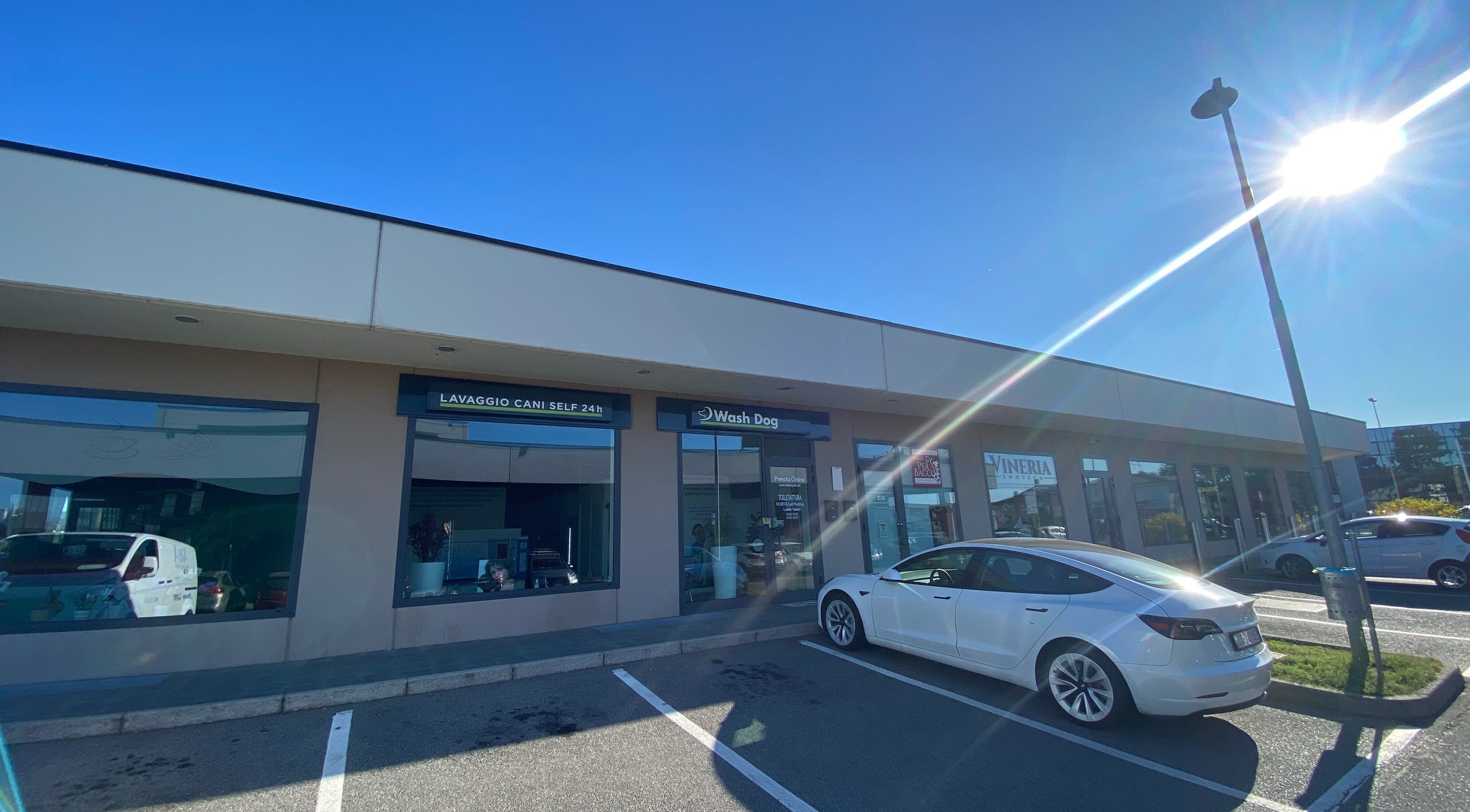 Esterno di AB Toelettatura Luxury Dalmine BG a Dalmine, Lombardia, IT con vetrine e auto parcheggiata.