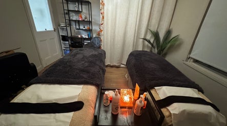 Relaxing massage room at Aesthetically Yours, Poynton, England, GB with cozy beds and warm lighting.