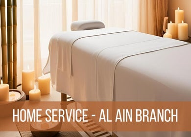 Relaxing massage table setup at La Poupee Home Service - Al Ain in Al Ain, AE, with candles and bamboo decor.