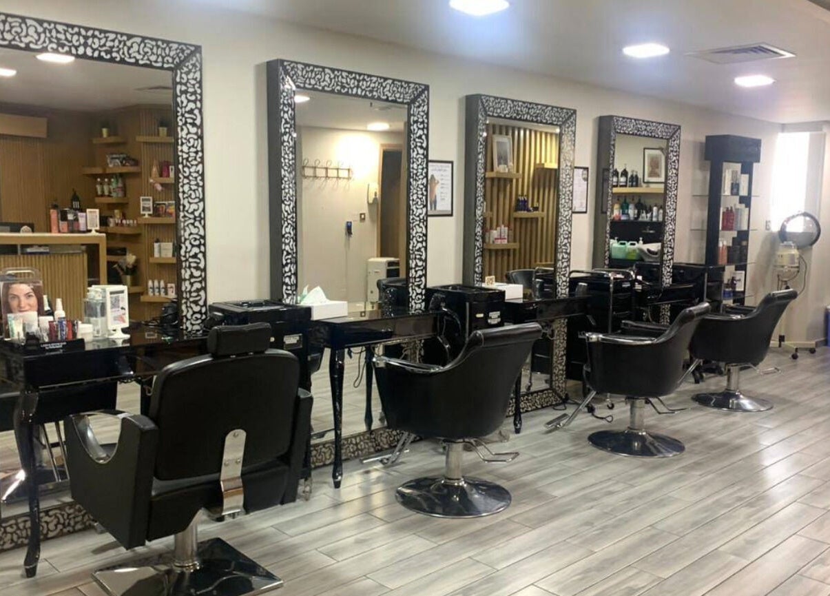 Elegant salon stations at La Poupee Home Service - Abu Dhabi, AE, featuring luxurious styling chairs and mirrors.