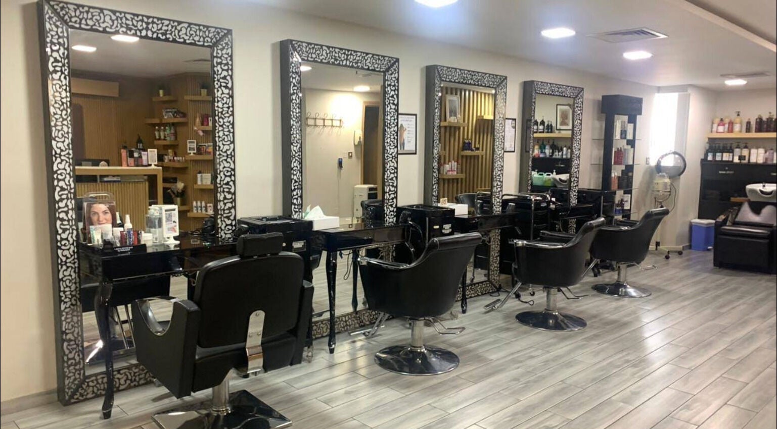 Elegant salon stations at La Poupee Home Service - Abu Dhabi, AE, featuring luxurious styling chairs and mirrors.