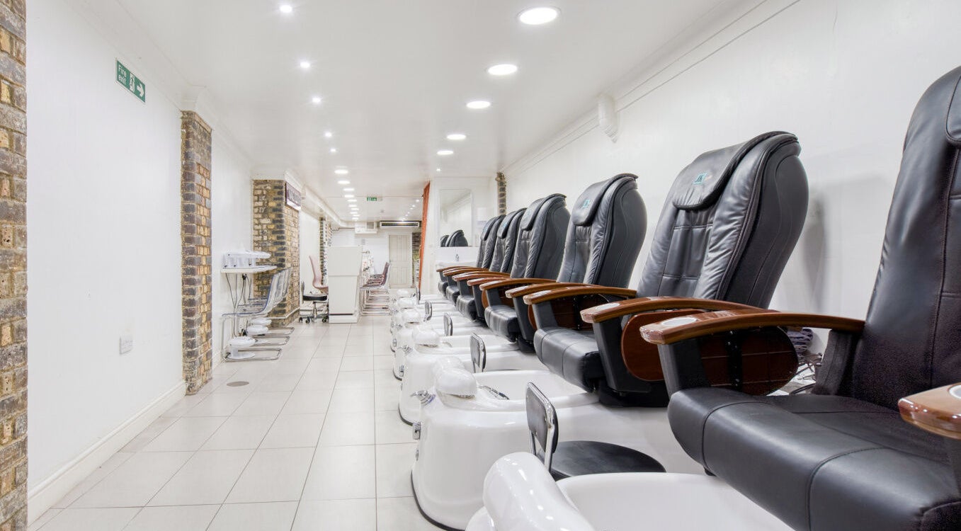 Spacious pedicure area at The Nail Lounge, London, England, GB, featuring modern chairs and soothing ambiance.