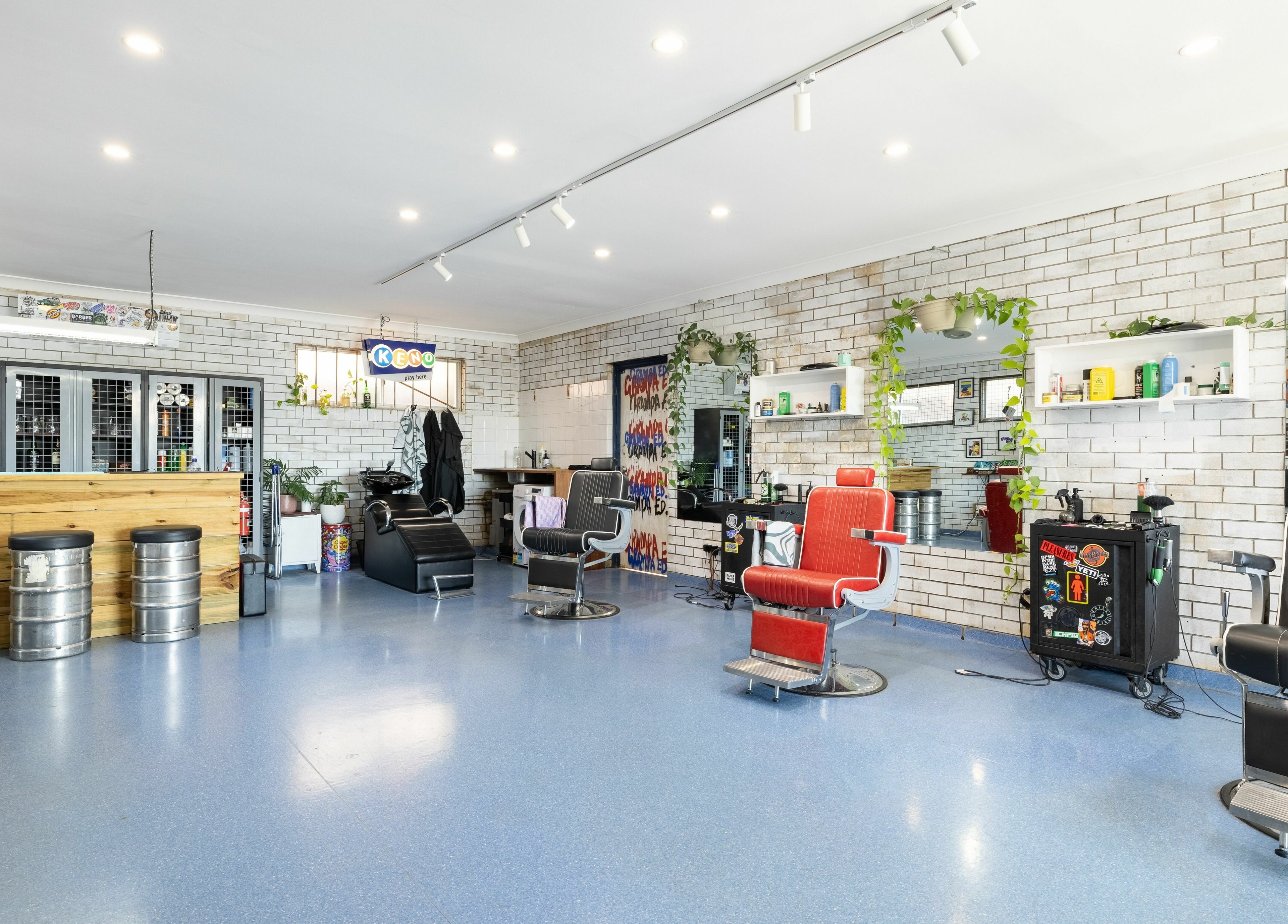 Chic barbershop at Grampa Ed, Banora Point, New South Wales, AU. Modern decor with stylish chairs and vibrant atmosphere.