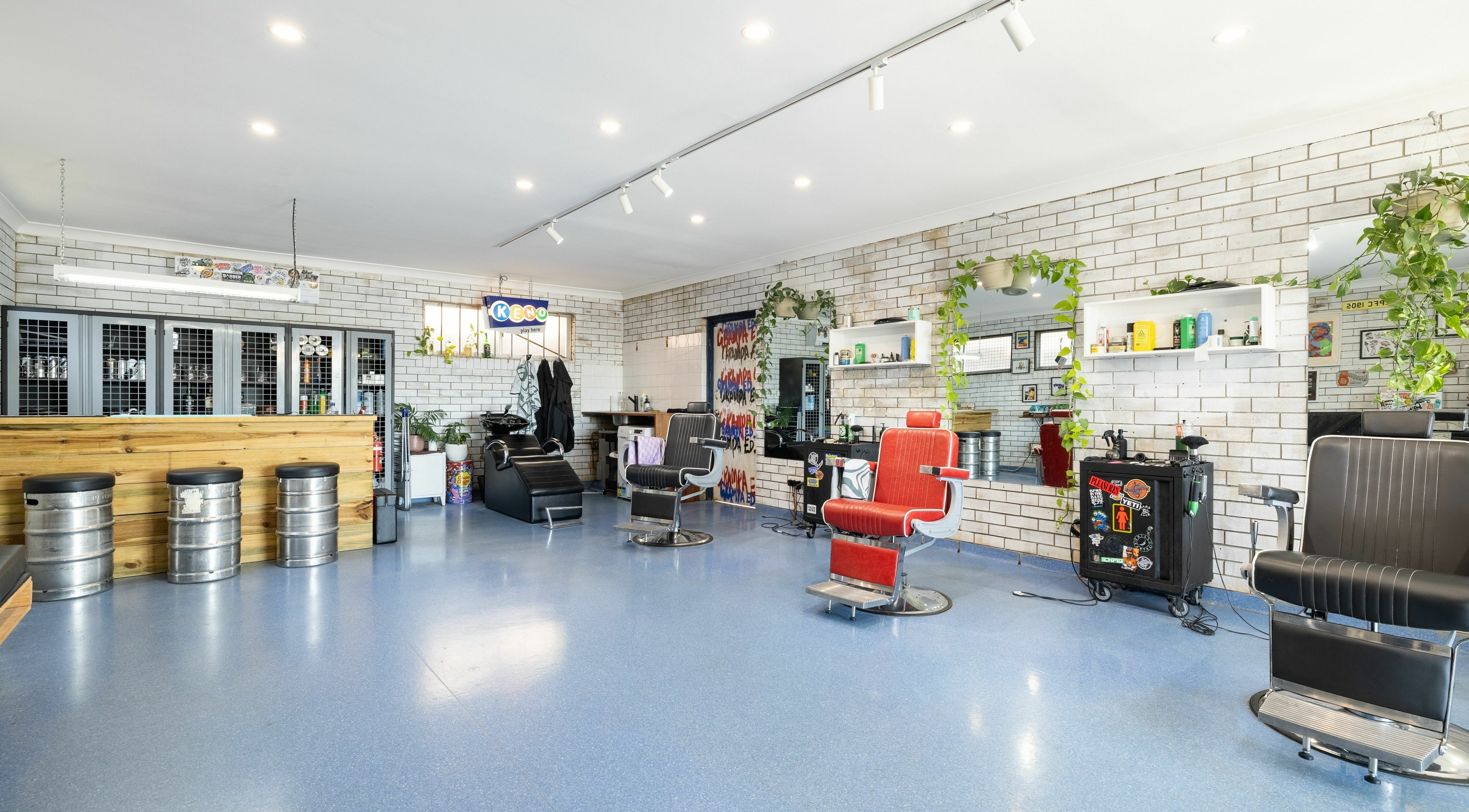 Chic barbershop at Grampa Ed, Banora Point, New South Wales, AU. Modern decor with stylish chairs and vibrant atmosphere.