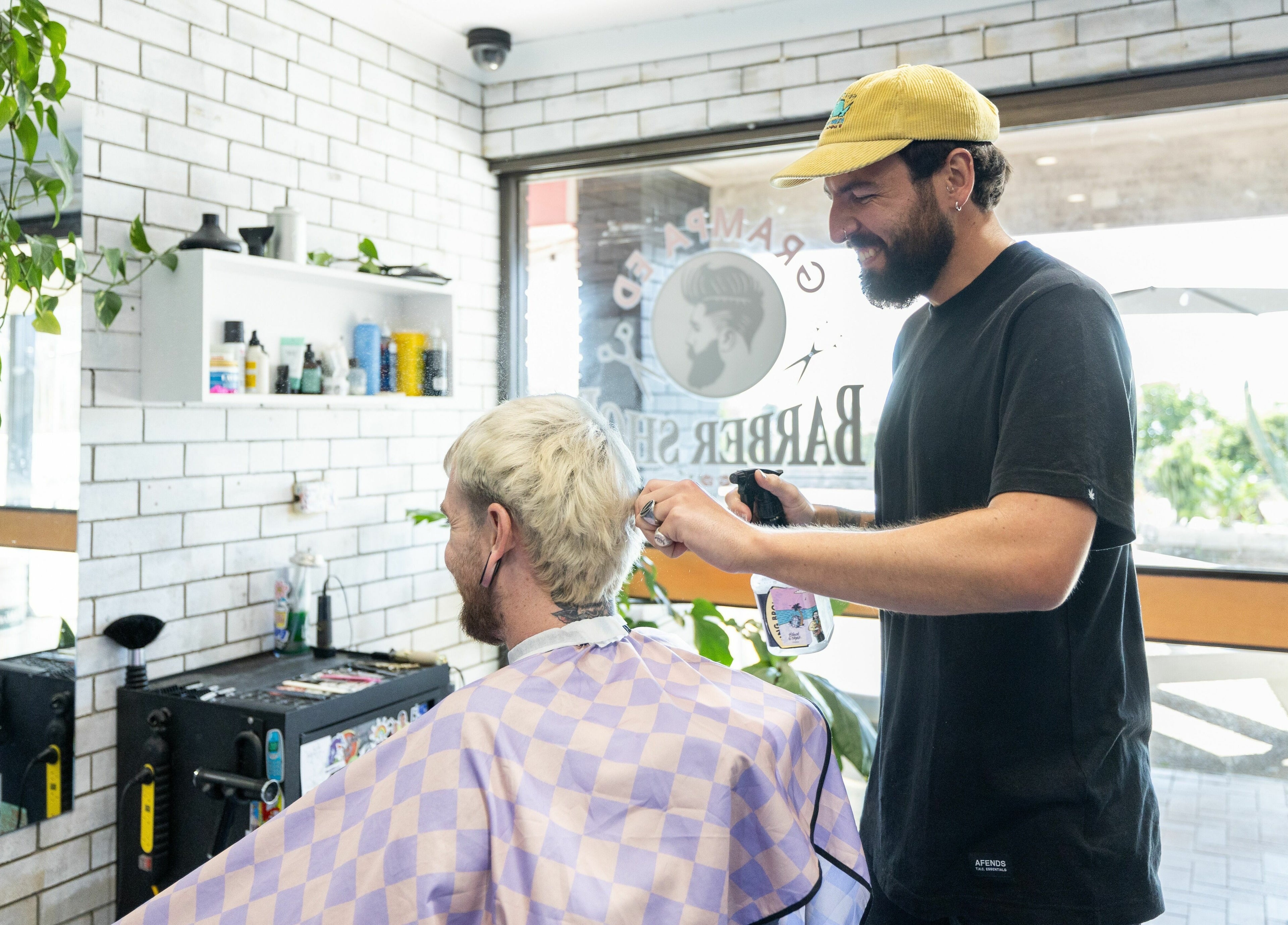 Hairdresser at Grampa Ed, Banora Point, New South Wales, AU, expertly styling a client's hair.