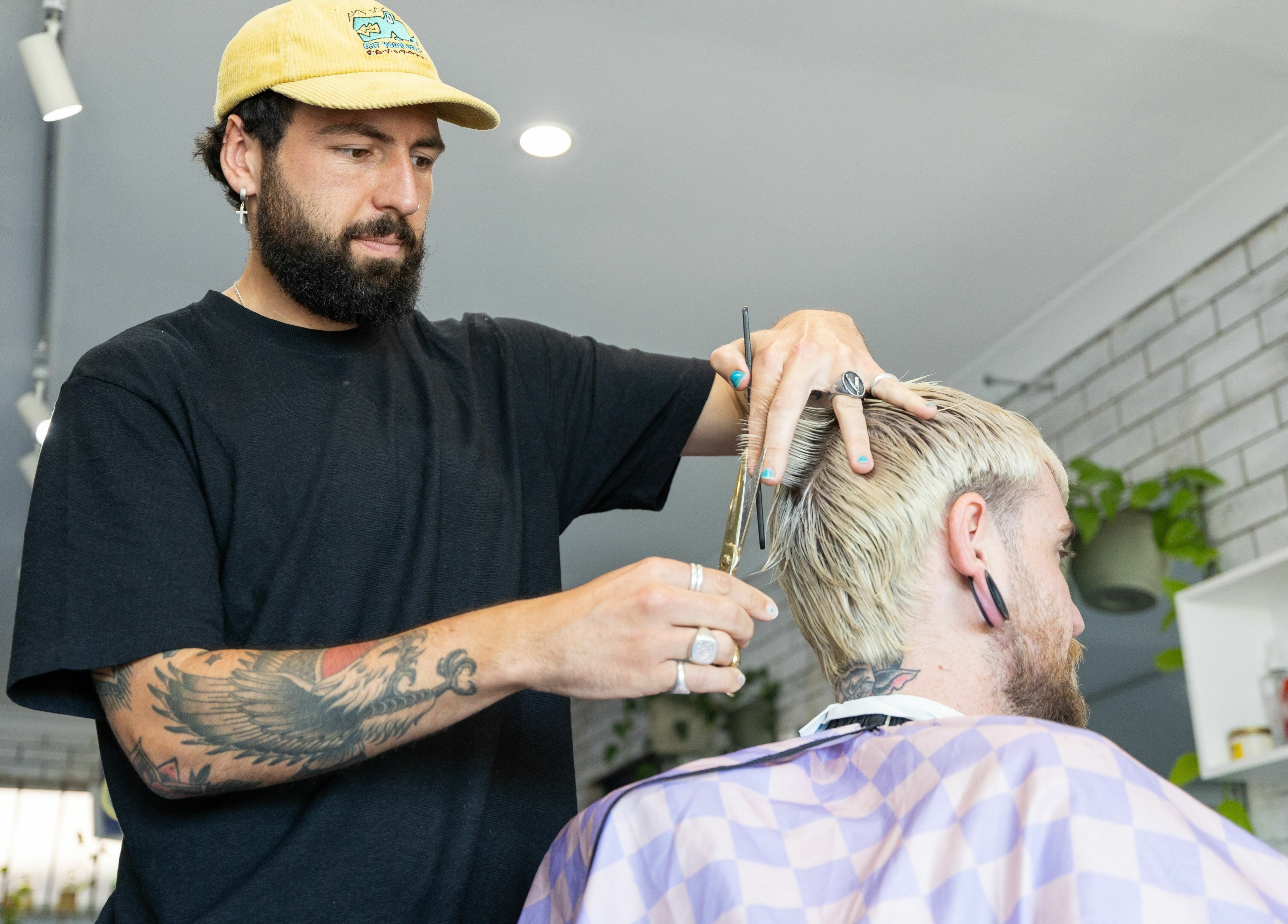 Barber styling a haircut at Grampa Ed, Banora Point, New South Wales, AU.