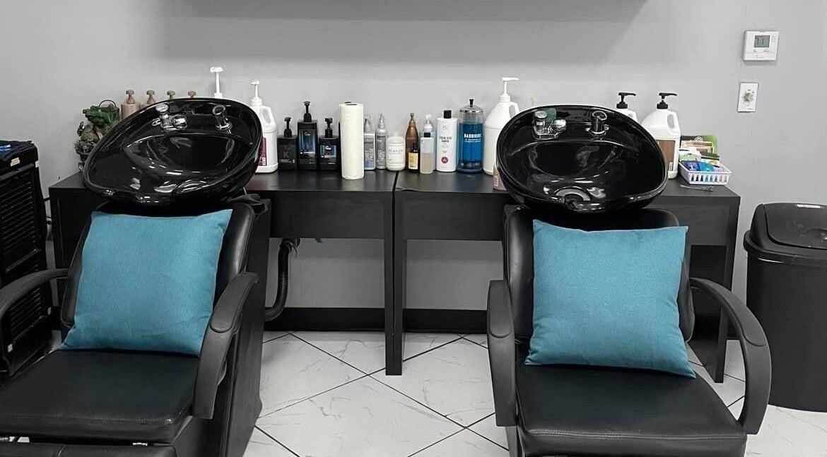 Elegant wash stations at Hair Makeover by Lupe, Bakersfield, California, US with black chairs and product display.