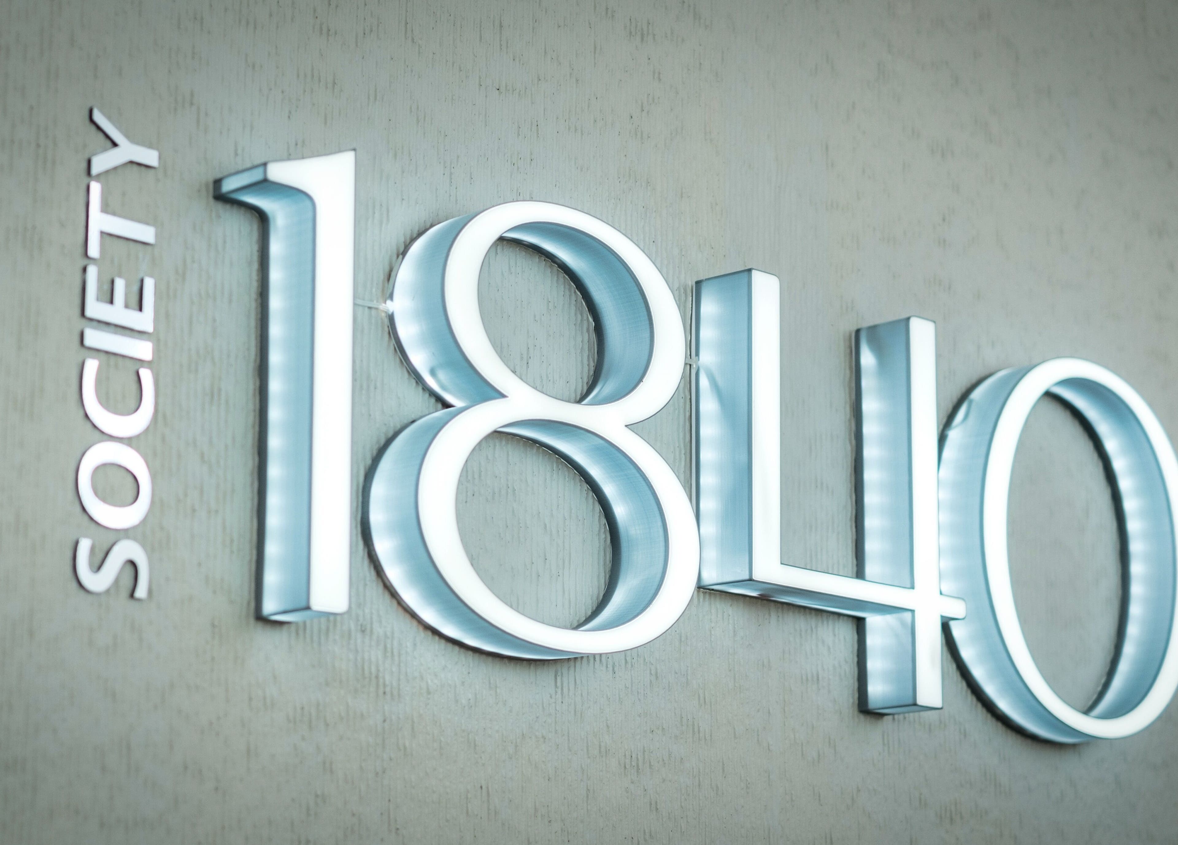 Illuminated 'Society 1840' sign at Johannesburg, Gauteng, ZA, reflecting modern elegance.