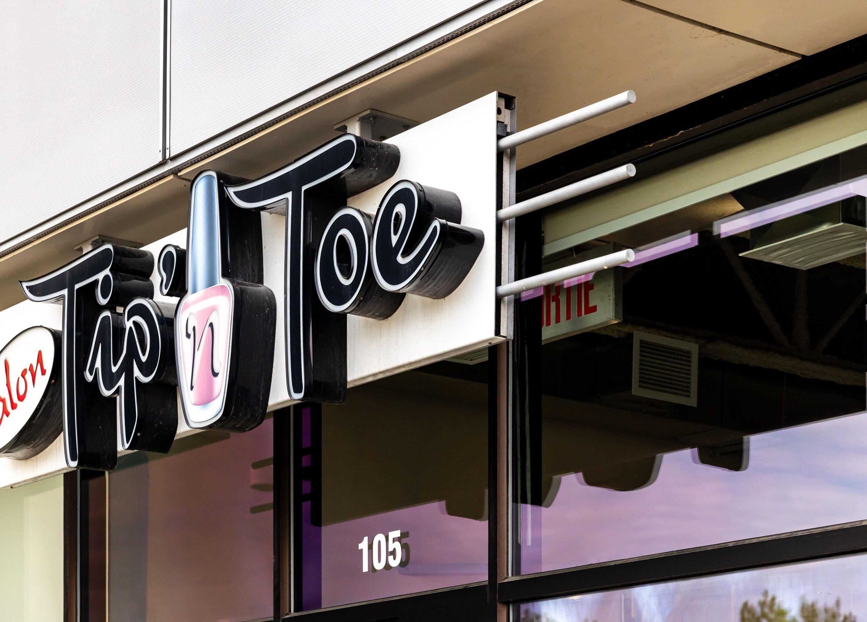 Enseigne du Salon Tip’ n Toe à Brossard, Québec, CA, mettant en avant sa façade moderne.