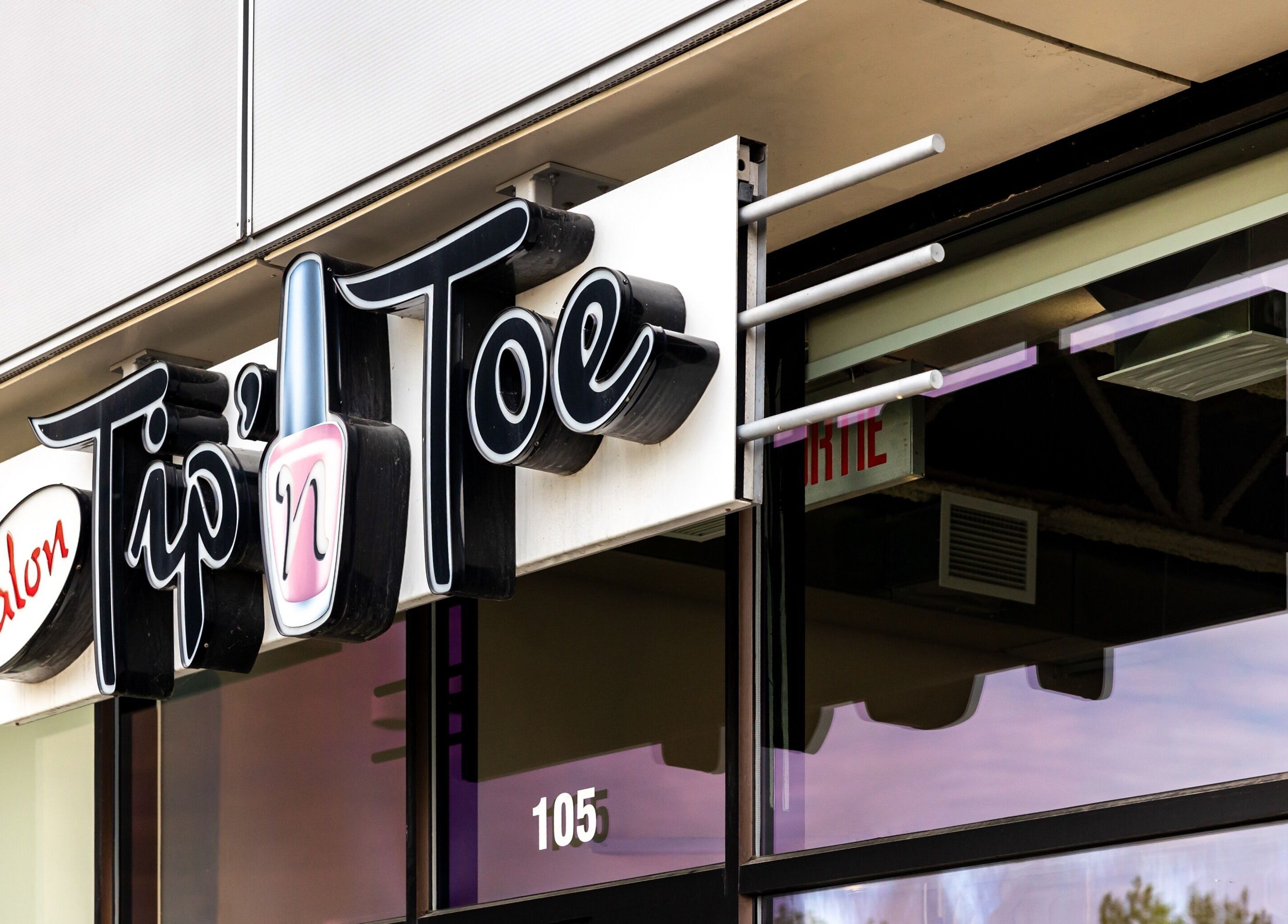 Enseigne du Salon Tip’ n Toe à Brossard, Québec, CA, mettant en avant sa façade moderne.