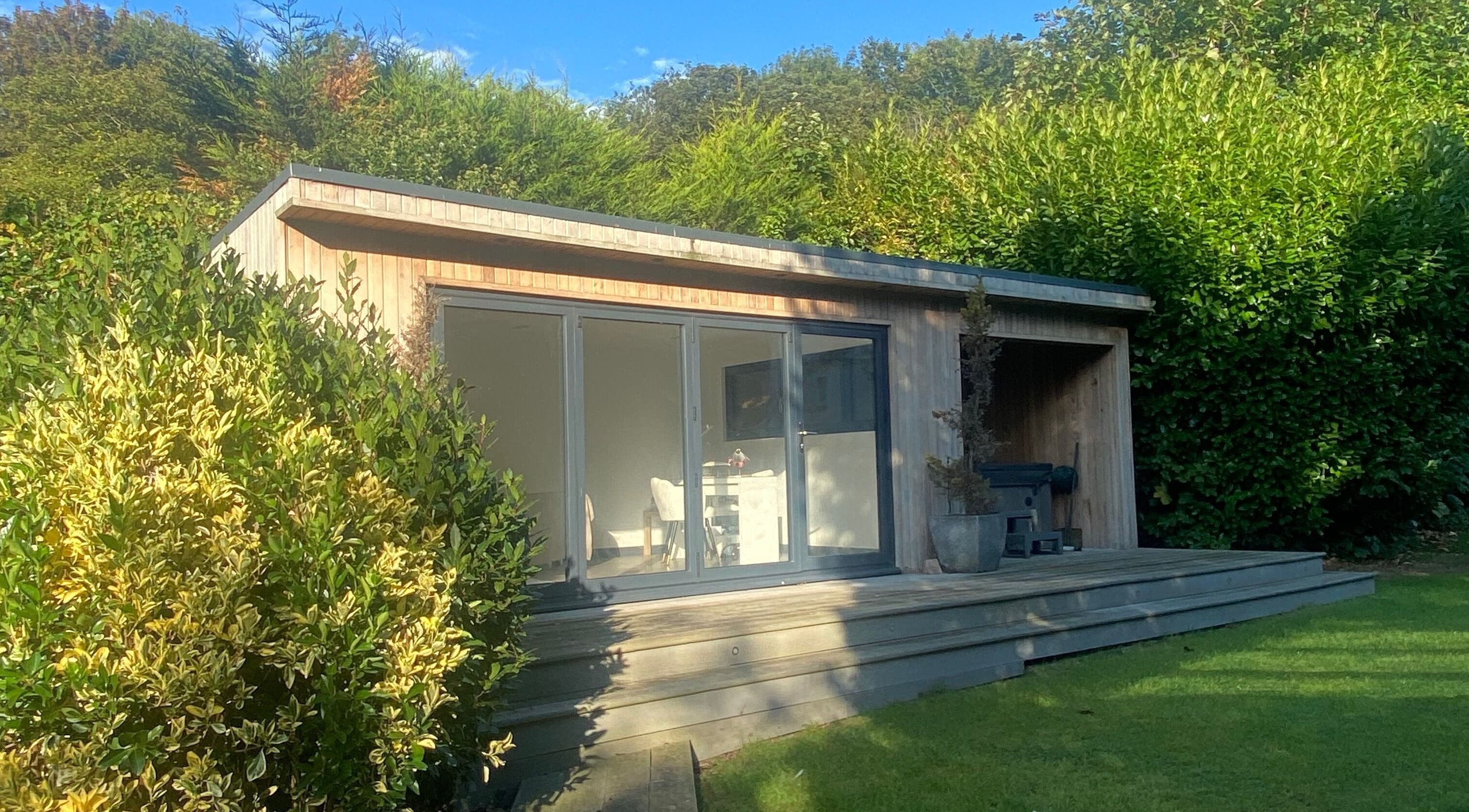 Wooden cabin at Elle Louise Beauty in Watnall, England, GB, surrounded by lush greenery.