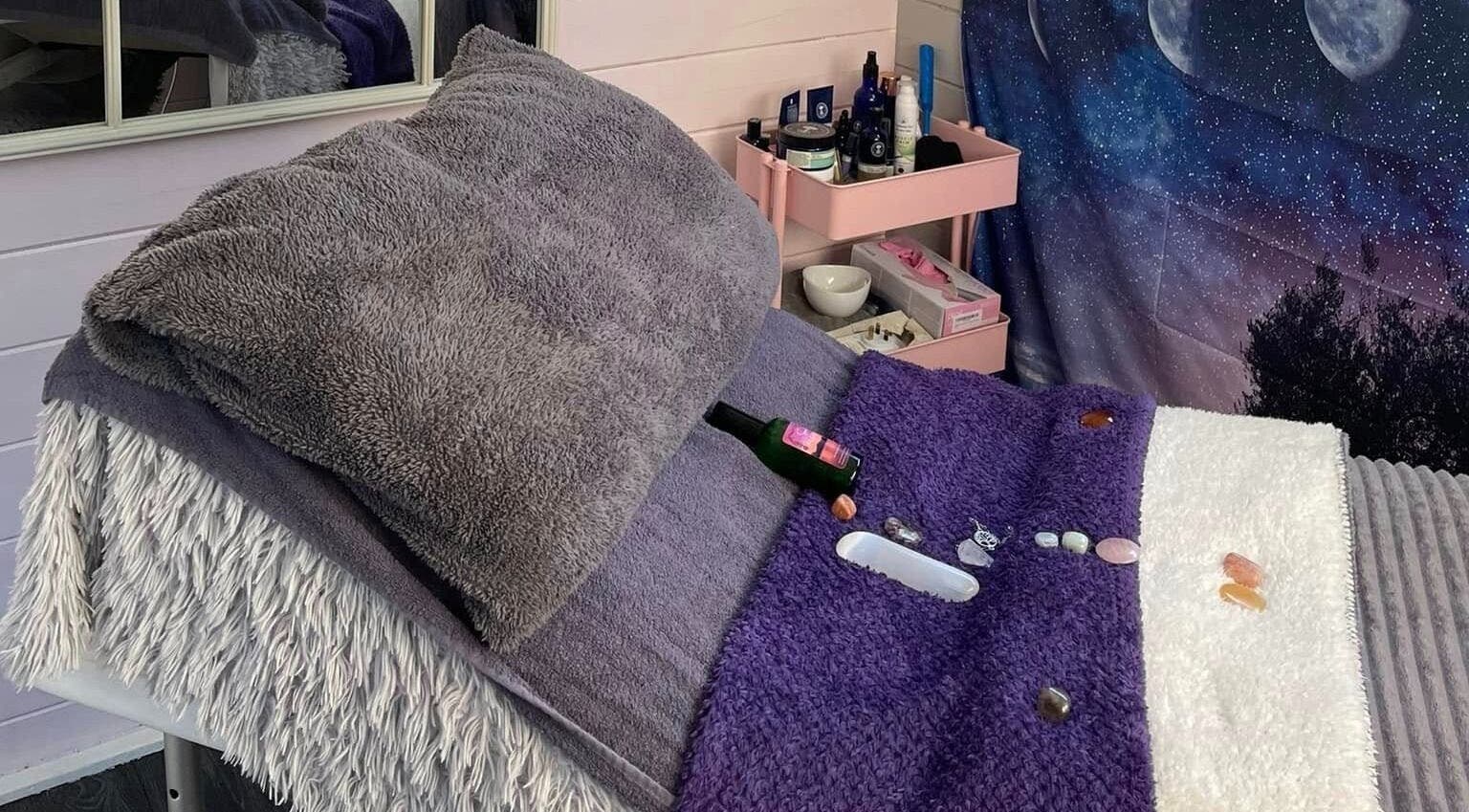 Cozy therapy bed at Twilight Garden Complementary Therapies, Chelmsford, England, GB, adorned with crystals.