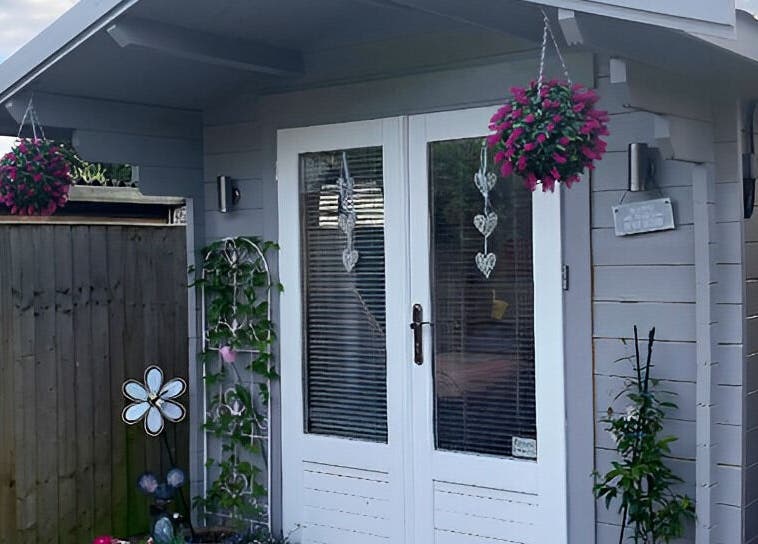 Cozy exterior at Twilight Garden Complementary Therapies, Chelmsford, England, GB, featuring vibrant hanging flowers.