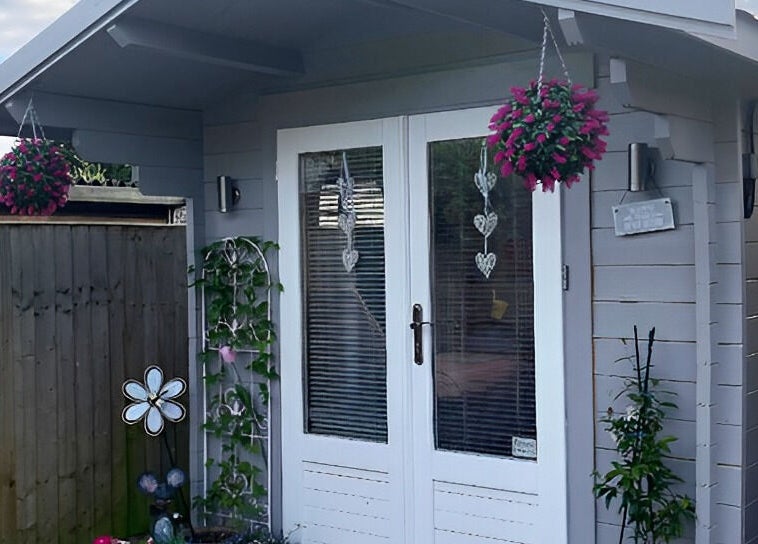 Cozy exterior at Twilight Garden Complementary Therapies, Chelmsford, England, GB, featuring vibrant hanging flowers.