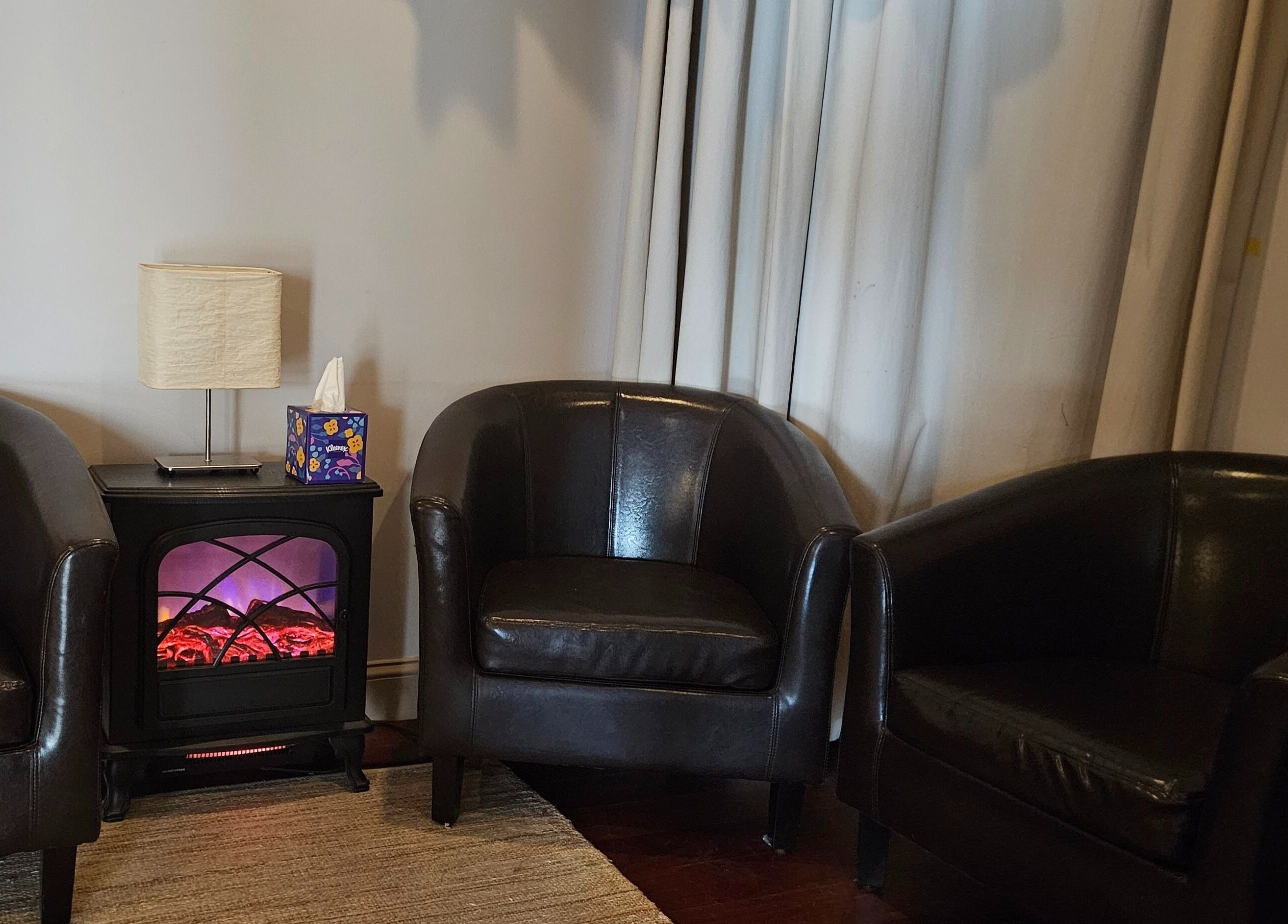 Joy Wellness for Life's cozy seating area with leather chairs and ambient lighting in Holbrook, Massachusetts, US.