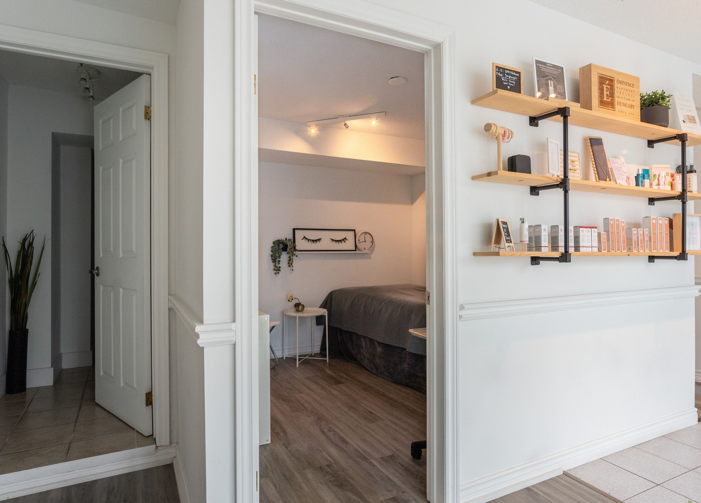 Cozy treatment room at Derma Luxe laser and skin, Cambridge, Ontario, CA with shelves displaying skincare products.