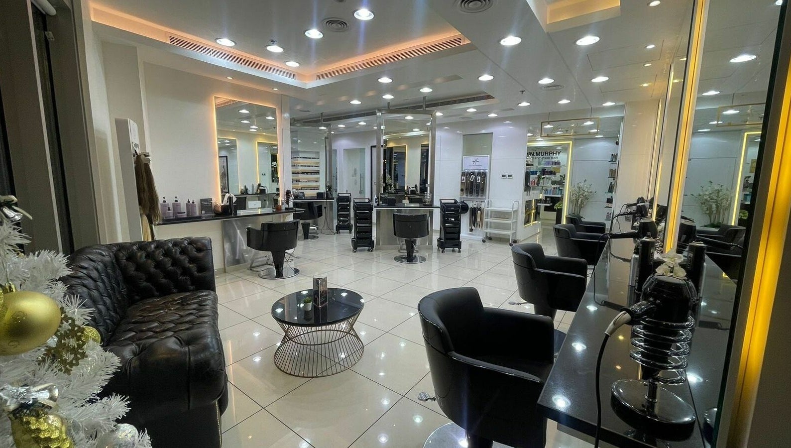 Luminous interior of Karim and Amin Salon in Dubai, AE with sleek chairs and mirrors.