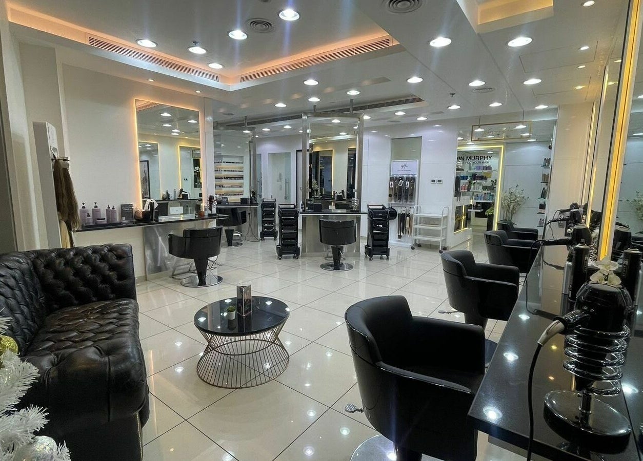 Luminous interior of Karim and Amin Salon in Dubai, AE with sleek chairs and mirrors.