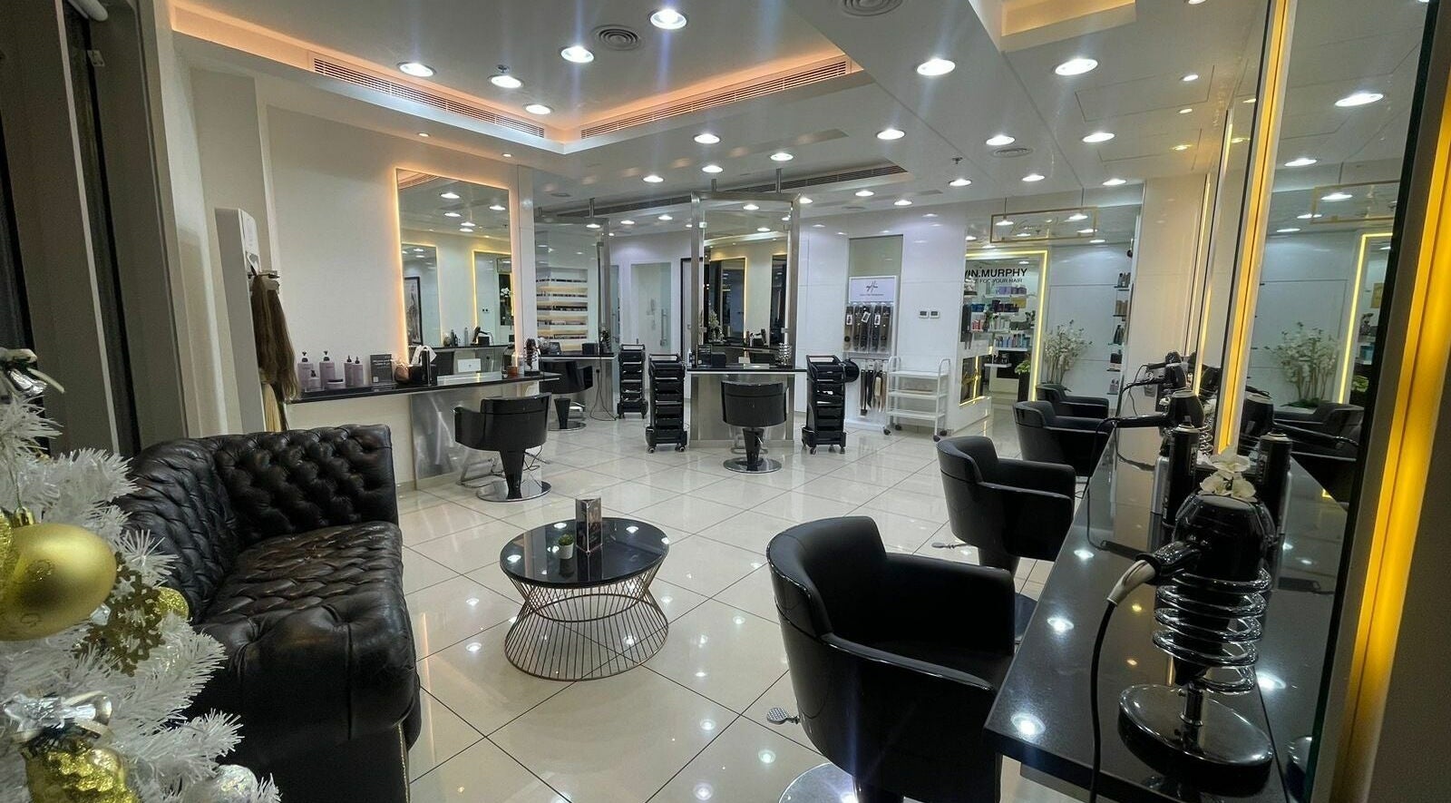Luminous interior of Karim and Amin Salon in Dubai, AE with sleek chairs and mirrors.