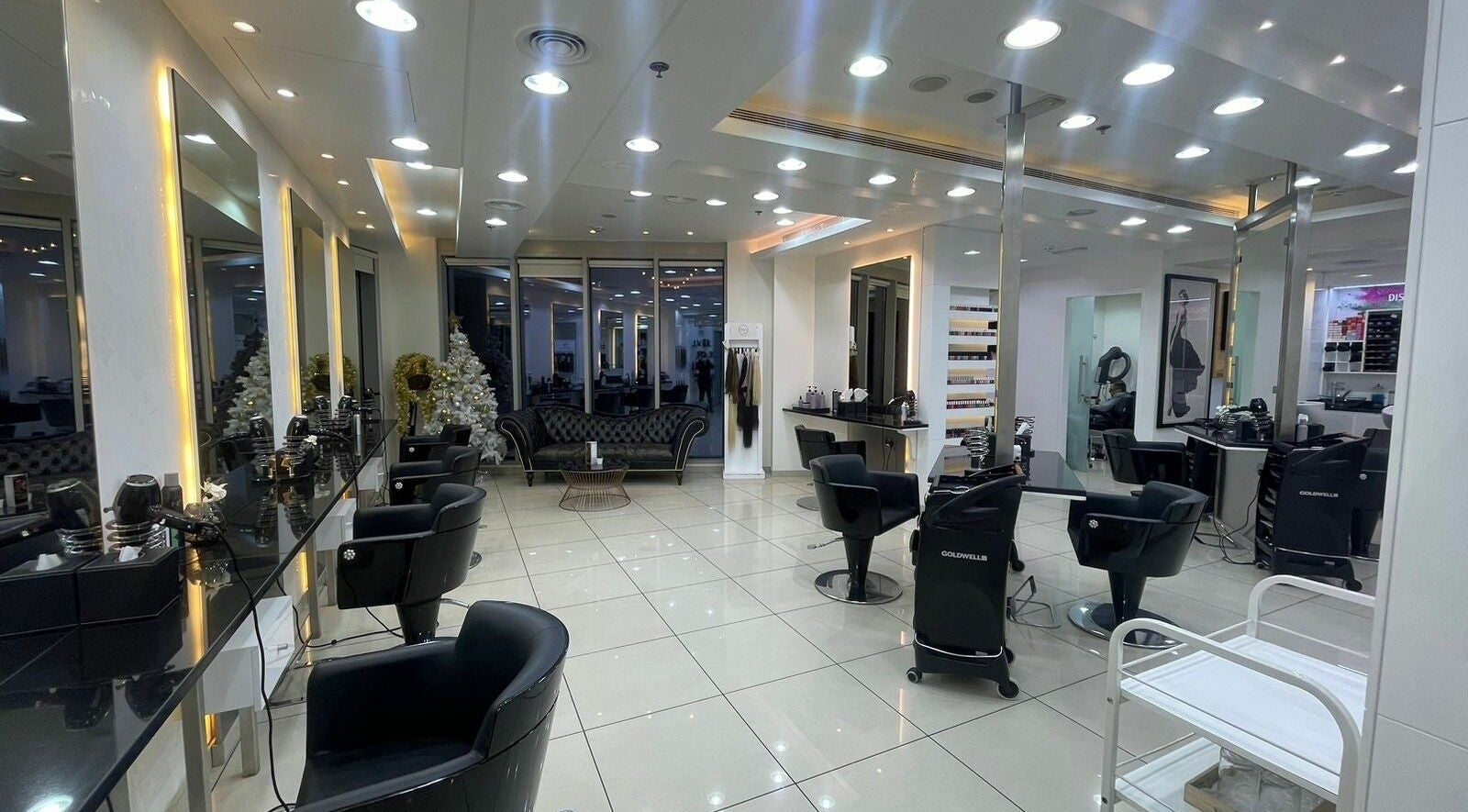 Elegant and modern interior of Karim and Amin Salon in Dubai, Dubai, AE featuring sleek black chairs and bright lighting.
