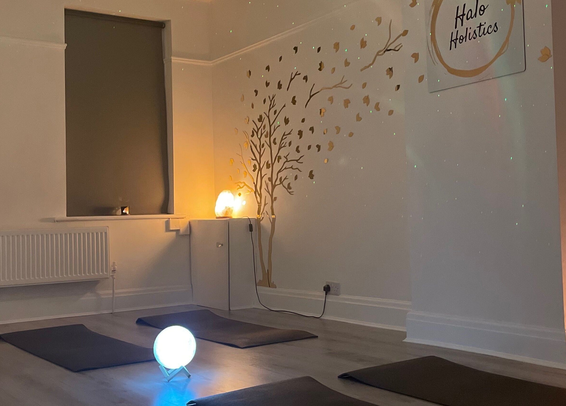 Tranquil yoga studio at Halo Holistics at Perfection Lounge, Whiston, England, GB with soft lighting and floor mats.