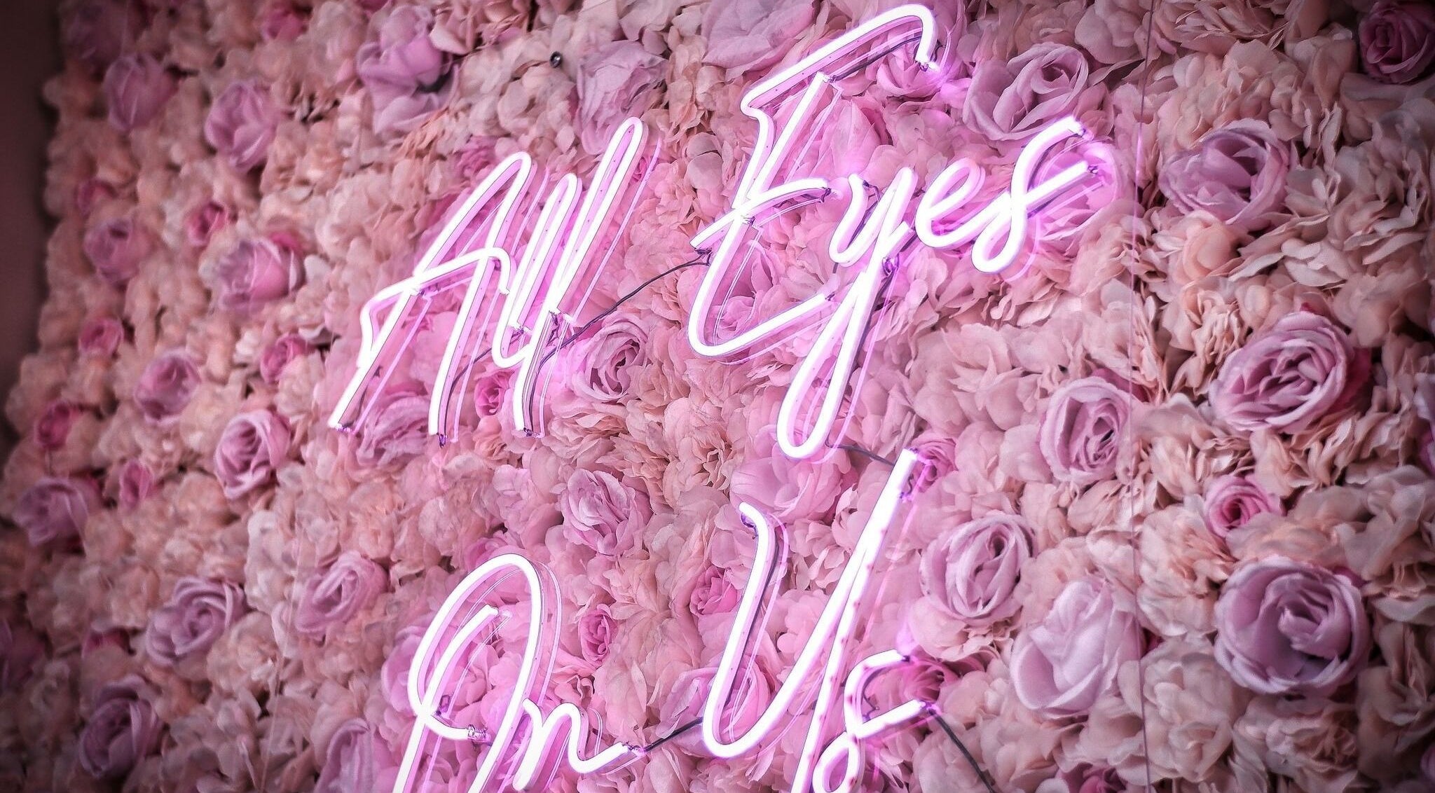 Neon sign 'All Eyes On Us' on floral wall at ELZYT, Drogheda, County Louth, IE.