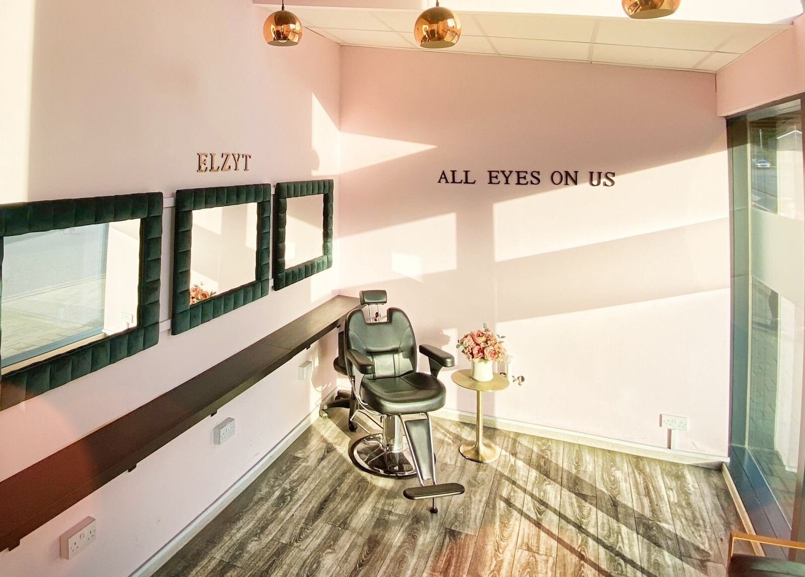 Modern salon interior at ELZYT, Drogheda, County Louth, IE, featuring stylish mirrors and a comfortable chair.
