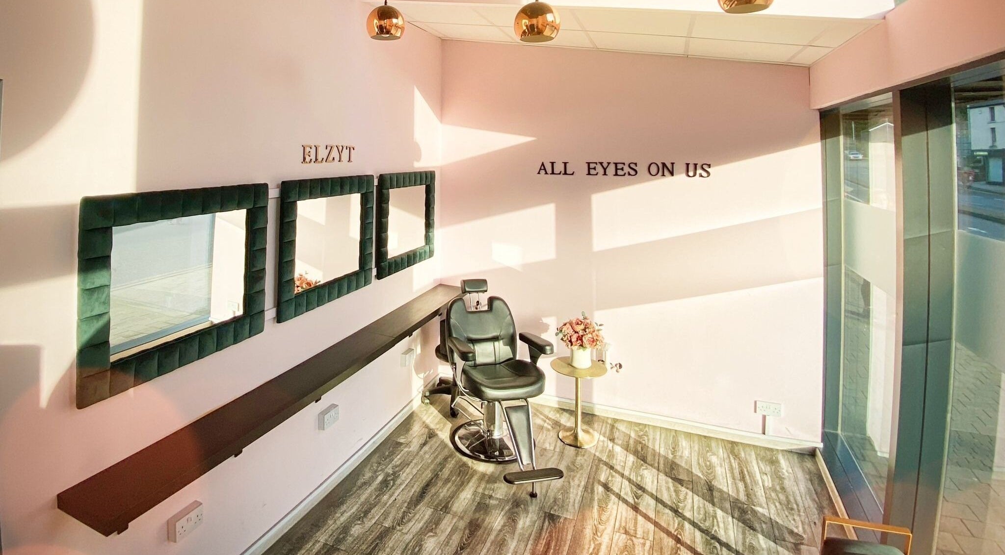 Modern salon interior at ELZYT, Drogheda, County Louth, IE, featuring stylish mirrors and a comfortable chair.