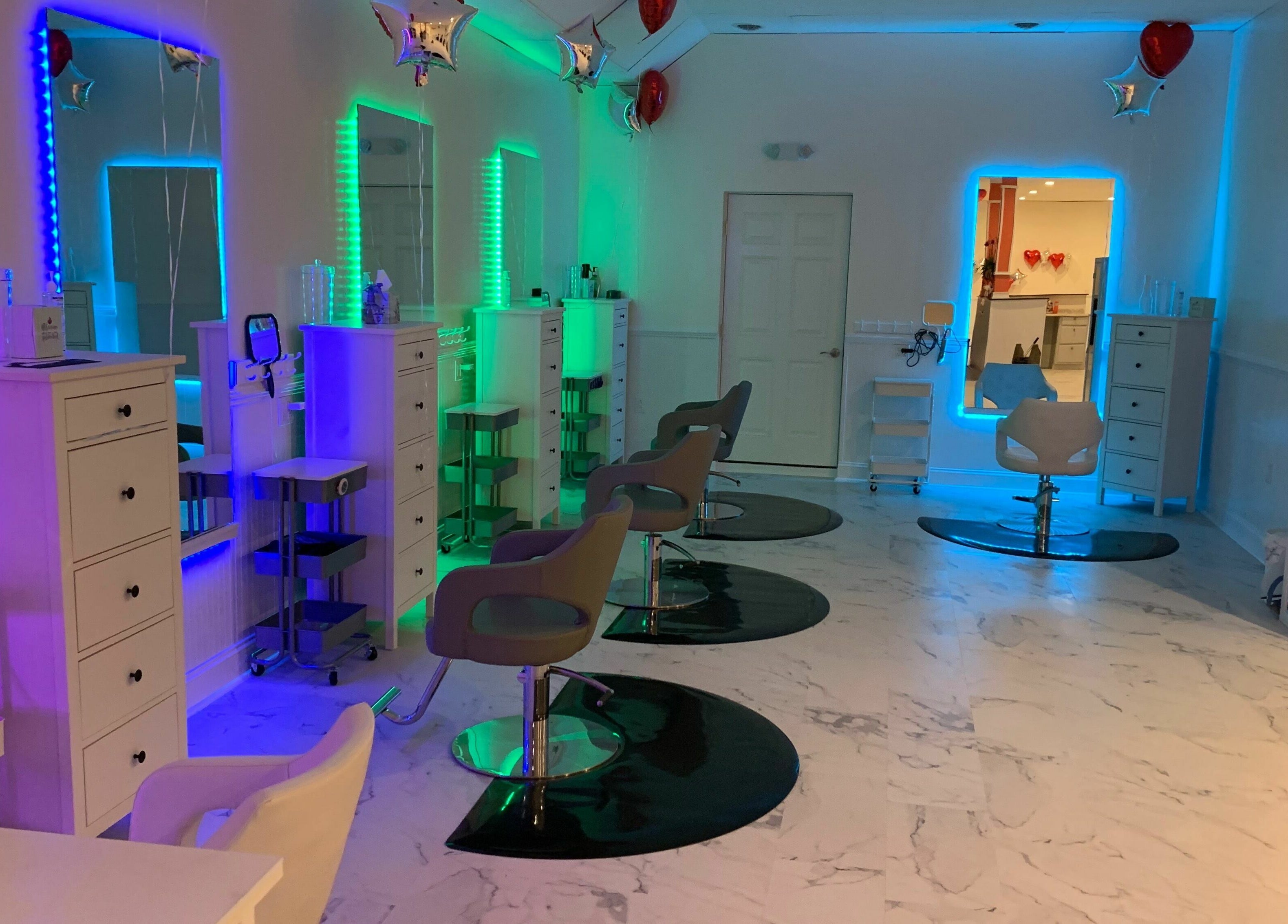 Chic beauty salon interior at Cevaluk, Waynesboro, Virginia, US, featuring colorful LED mirrors and styling chairs.