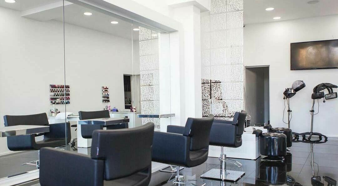 Modern salon interior at Maxx Mira Clinic, Enfield, England, GB with sleek black chairs and large mirrors.