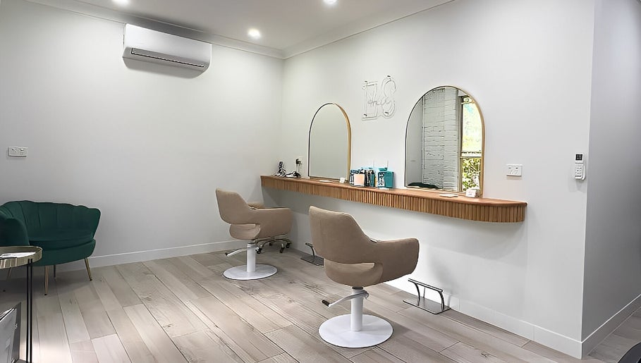 Modern salon interior at Erin Stevens Hair, Erskine Park, New South Wales, AU, featuring stylish seating and mirrors.