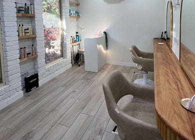 Stylish salon interior at Erin Stevens Hair, Erskine Park, New South Wales, AU, with elegant mirrors and plush chairs.