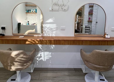 Stylish salon stations at Erin Stevens Hair, Erskine Park, New South Wales, AU with mirrors and chairs.