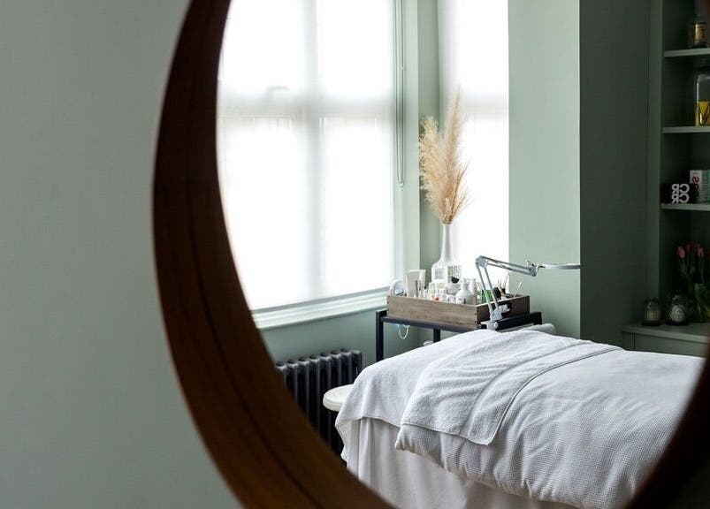 Tranquil treatment room at Victoria Cheek Facialist, Leigh-on-sea, England, GB, seen through a round mirror.