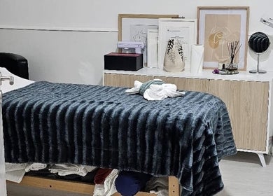 Sala de tratamento acolhedora na MF Skin D'Lux, Lisboa, Lisboa, PT, com móveis elegantes e decoração suave.