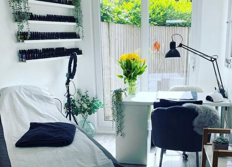 Bright beauty room at Practically Perfect in Every Way, Tewin, England, GB with bed, nail polish display, and greenery.