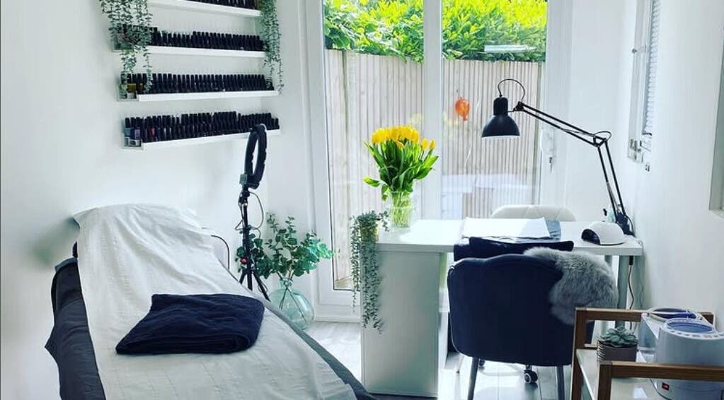 Bright beauty room at Practically Perfect in Every Way, Tewin, England, GB with bed, nail polish display, and greenery.