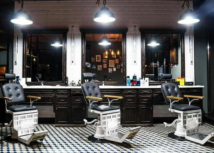 Interior elegant la Barber Society, Cluj-Napoca, Județul Cluj, RO, cu scaune de barberie clasice și lumini calde.
