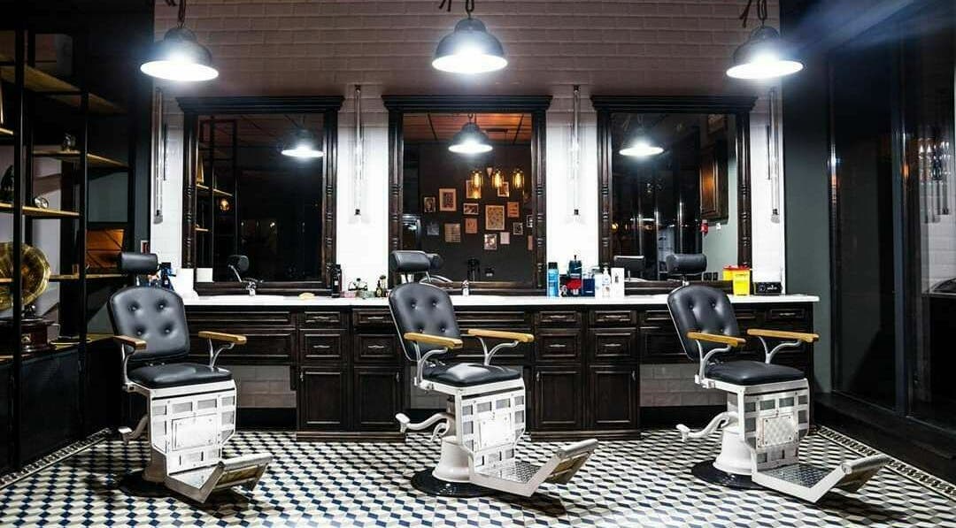 Interior elegant la Barber Society, Cluj-Napoca, Județul Cluj, RO, cu scaune de barberie clasice și lumini calde.