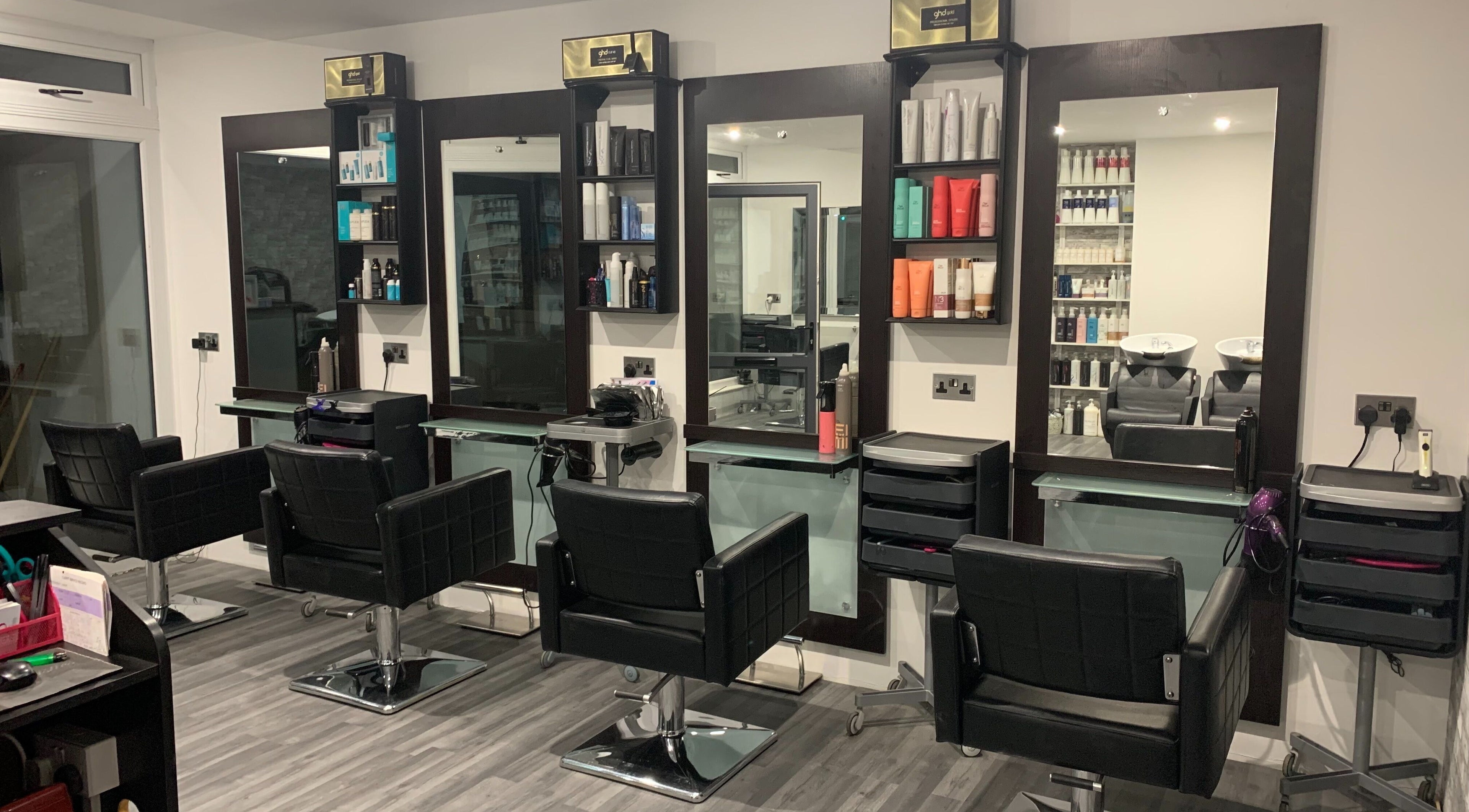 Modern salon interior at Stylistics, Jersey, St Saviour, GB, showcasing styling stations and products.